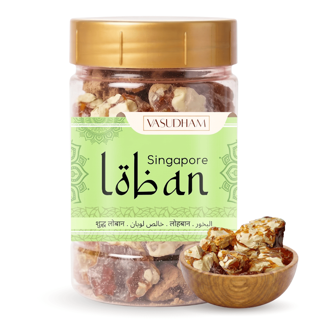 A clear plastic jar of Vasudhami Singapore loban with a gold lid and a light green label, shown alongside a small wooden bowl of the loban on a white background.