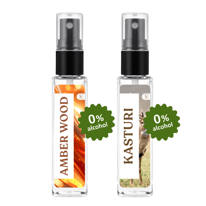 Two clear glass perfume spray bottles with black pumps, labeled Amber Wood and Kasturi, shown side by side on a white background with green '0% alcohol' badges.