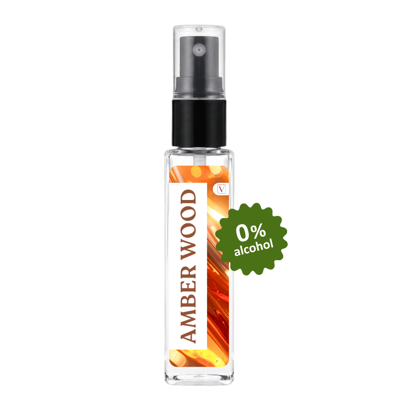 A clear glass perfume or fragrance spray bottle with a black pump and a white label reading 'AMBER WOOD' on a white background. A green burst sticker says '0% alcohol'.