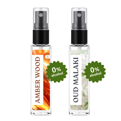 Two clear glass perfume spray bottles with black pumps, labeled Amber Wood and Oud Malaki, shown side by side on a white background with green '0% alcohol' badges.