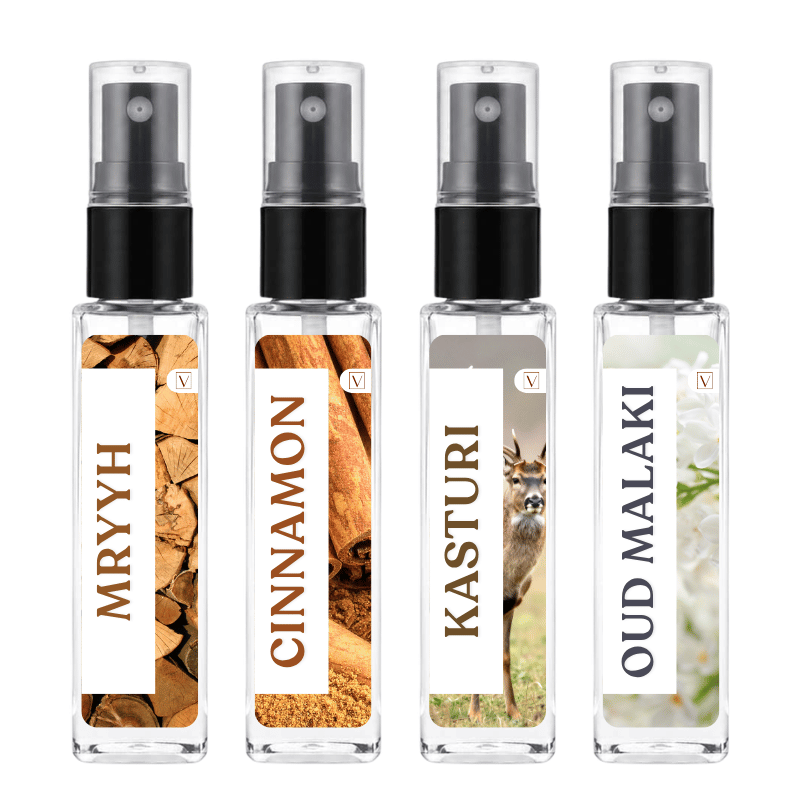 Four clear glass perfume spray bottles with black atomizers and white labels, shown side by side on a white background. The labels read MRYYH, CINNAMON, KASTURI, and OUD MALAKI, with wood and animal imagery on the first two and a white floral image on the last.