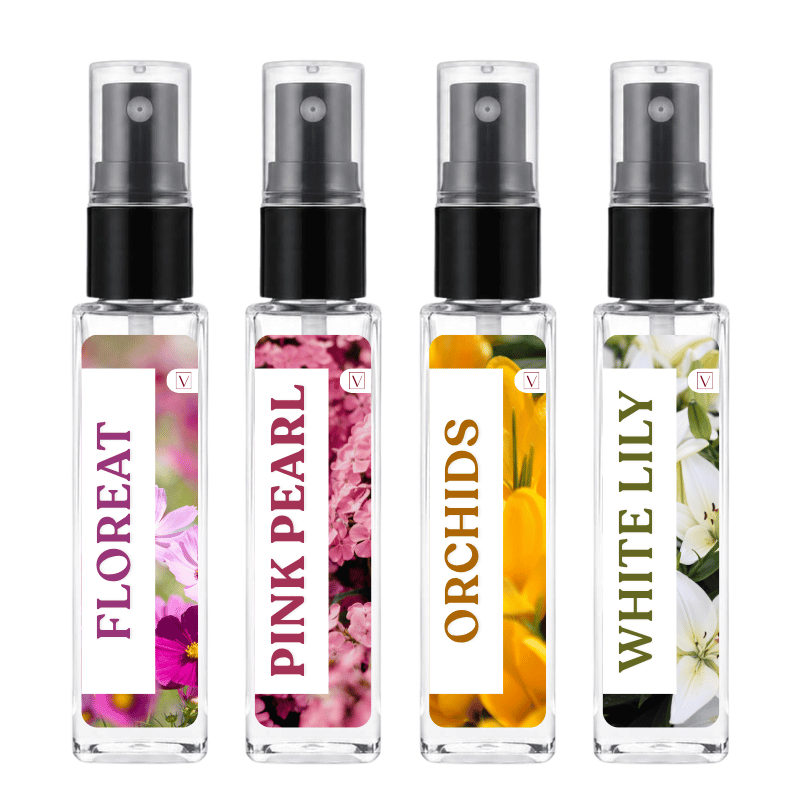 Four clear glass perfume spray bottles with black pumps, shown side by side on a white background. The labels read FLOREAT, PINK PEARL, ORCHIDS, and WHITE LILY, with floral imagery in pink, magenta, yellow, and white.