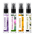 Four small clear spray bottles with black pumps and floral labels, labeled Lavender, Pink Lotus, Orchids, and White Lily, shown on a white background.