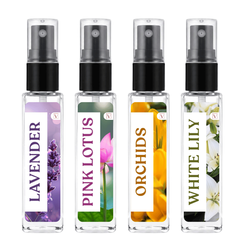 Four small clear spray bottles with black pumps and floral labels, labeled Lavender, Pink Lotus, Orchids, and White Lily, shown on a white background.