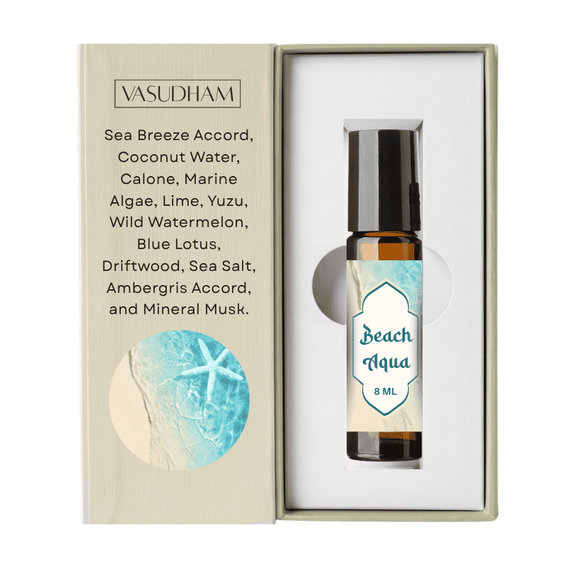 A 10ml rollerball essential oil bottle labeled 'Beach Aqua' by VASUDHAM, displayed inside its open presentation box. The box features a beige textured cover with a blue starfish graphic and a list of scent notes including Sea Breeze Accord and Coconut Water.