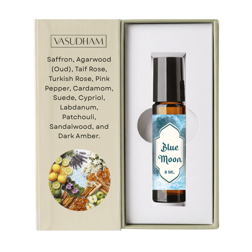 A 8 ml bottle of Vasudham Blue Moon essential oil roll-on, presented inside its open gift box next to its printed packaging insert.
