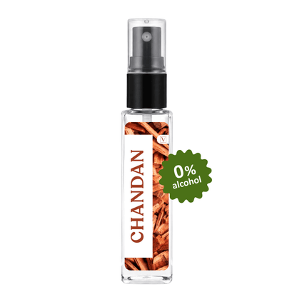 A clear glass perfume spray bottle with a black pump, featuring a white label with vertical 'CHANDAN' text and cinnamon illustrations. A green '0% alcohol' badge is overlaid on the right side, set against a plain white background.