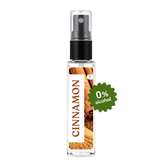 A clear glass perfume or diffuser spray bottle with a black pump, labeled CINNAMON with cinnamon imagery, and a green badge reading 0% alcohol, on a white background.