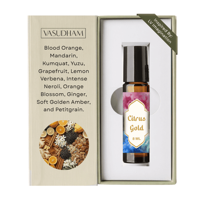 Vasudham Citrus Gold 8ml rollerball perfume oil shown in its open presentation box. The left panel lists ingredients including blood orange, mandarin, and ginger, while the right side displays the amber glass bottle with a black cap and a pink and blue gradient label.