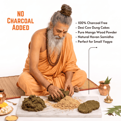 An elderly man with a long white beard and hair in a bun sits cross-legged on a woven mat, preparing a havan samidha (wood powder) on a white marble slab. He is wearing orange robes and a beaded necklace.