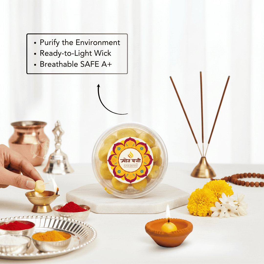 A clear round container of yellow flower light sticks sits on a white marble board on a table, surrounded by ritual props including a brass incense holder, copper bells, a diya, and a hand lighting a small flame. Text on the image lists product features.