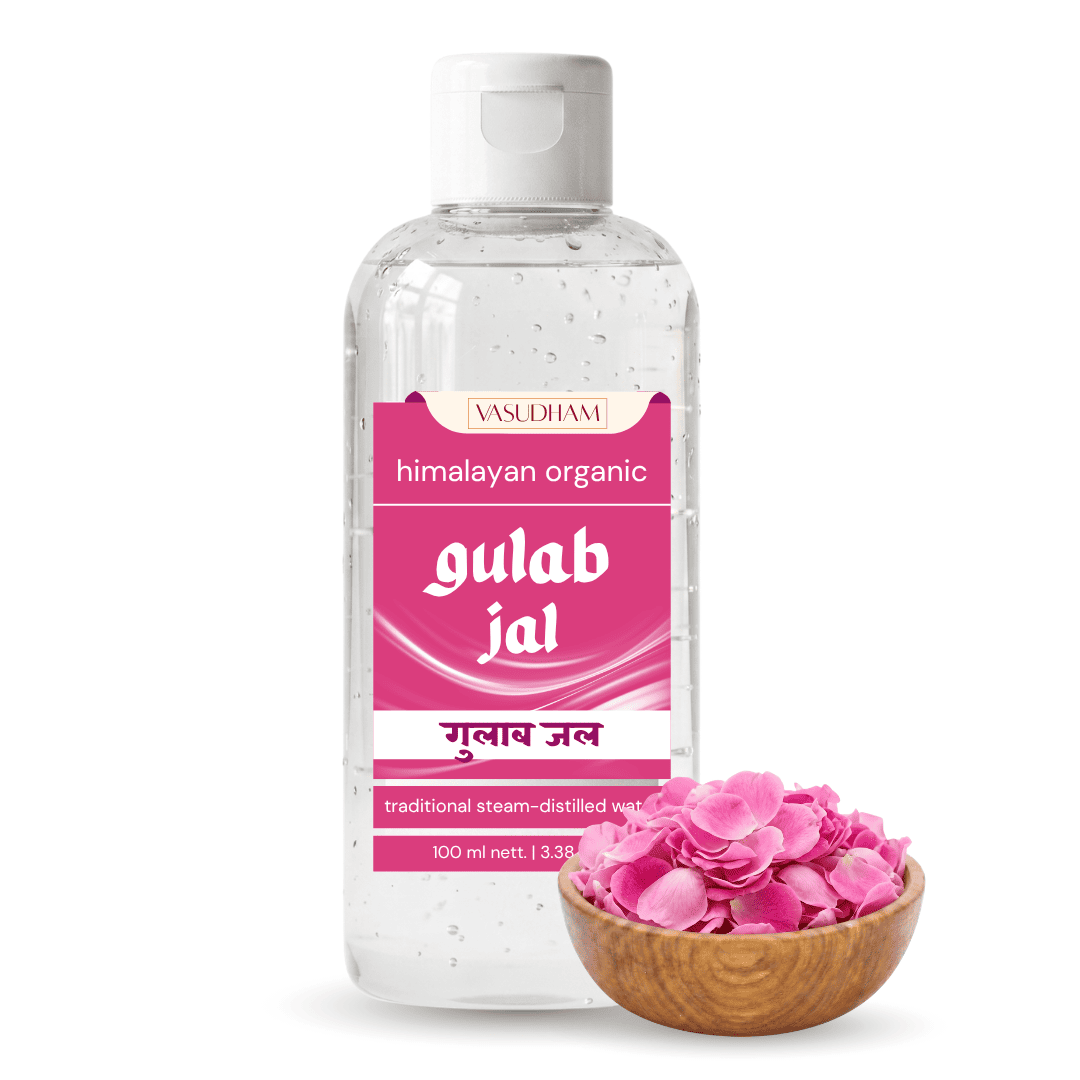 A 100 ml bottle of Vasuham Gulab Jal traditional steam-distilled rose water, shown next to a small wooden bowl filled with pink rose petals on a white background.