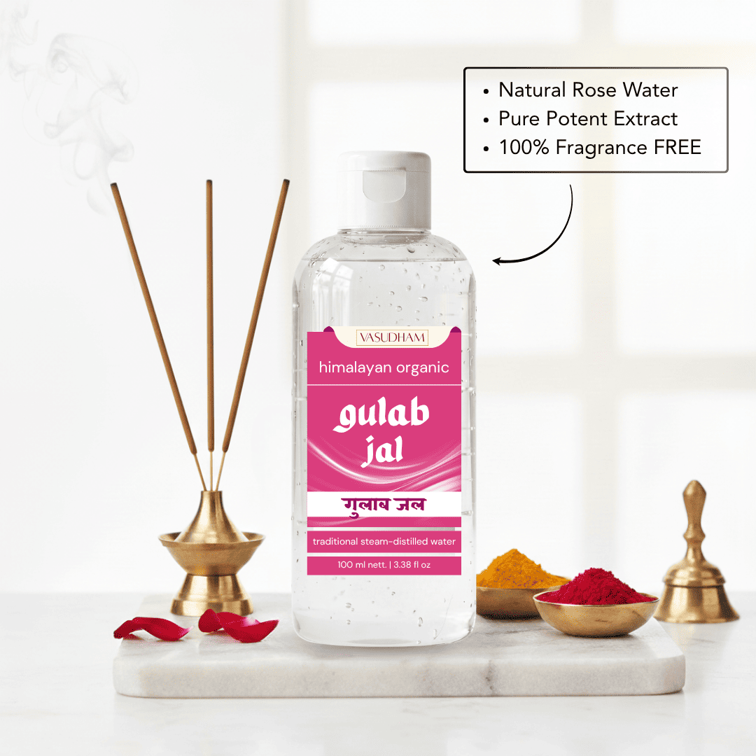 A bottle of Gulab Jal traditional steam-distilled water by Vasudham, displayed on a white marble tray with incense sticks, rose petals, and bowls of spices. A text overlay highlights the natural rose water and potent extract ingredients.