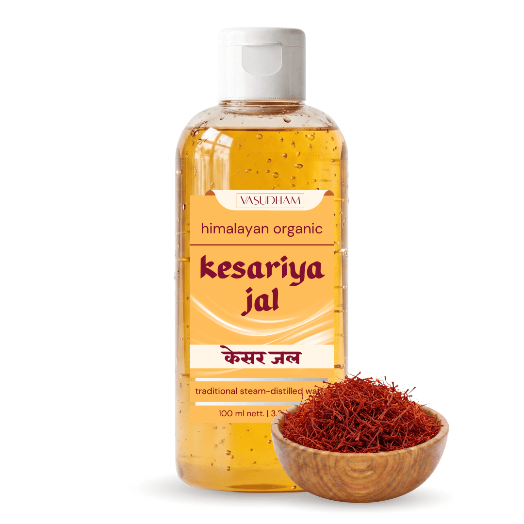 A bottle of Vasudham Himalayan Organic Kesariya Jal (himalayan red ghee) next to a small wooden bowl filled with saffron threads, on a white background.