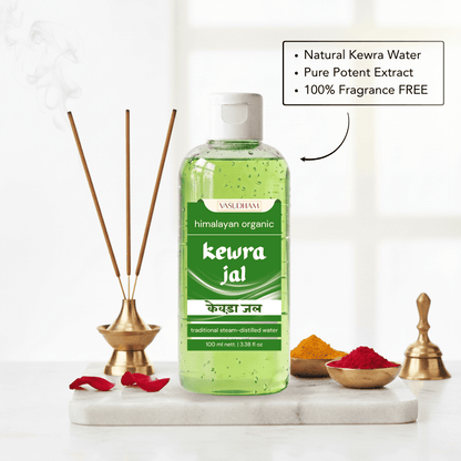 A bottle of Himalayan Kewra Jal essential oil diffuser liquid, filled with green liquid and featuring a white cap, displayed on a marble tray with incense sticks, brass bells, and spices against a bright, softly blurred background.