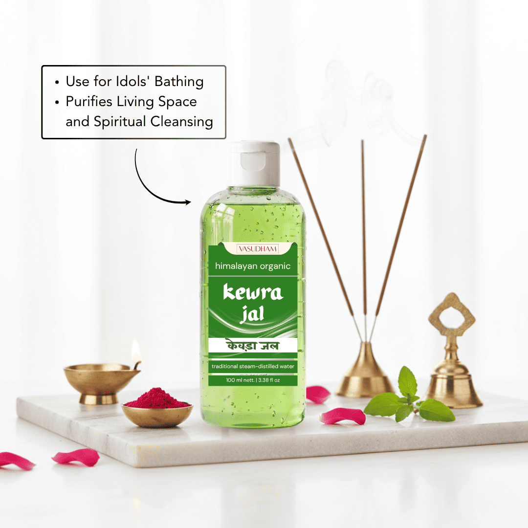 A bottle of Kewra Jal Himachal Organic bath liquid is displayed on a white marble tray with decorative bath props including brass oil lamps, incense sticks, mint leaves, and pink petals. A text box on the left highlights its benefits for cleansing.
