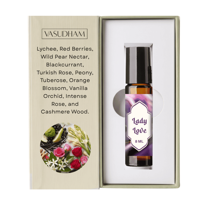 A 8 ml rollerball essential oil bottle labeled 'Lady Love' by VASUDHAM, presented inside an open beige gift box with a printed ingredient list and floral illustration.