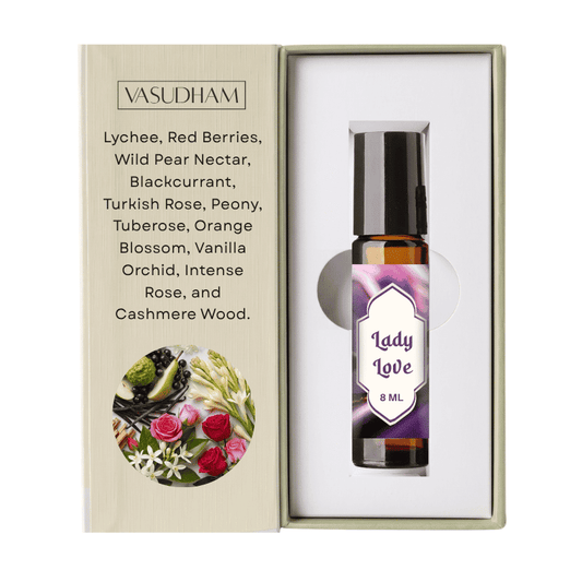 A 8 ml rollerball essential oil bottle labeled 'Lady Love' by VASUDHAM, presented inside an open beige gift box with a printed ingredient list and floral illustration.