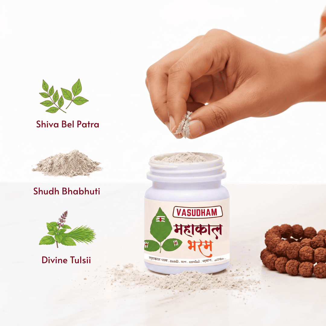 A white plastic jar labeled VASUDHAM mahakal bhasm with a hand sprinkling silver beads into it, shown on a white background with ingredient callouts for Shiva Bel Patra, Shudh Bhabhuti, and Divine Tulsii, plus a cluster of brown prayer beads on the right.