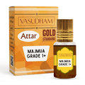 Vasudham Attar Gold Standard Majmuja Grade 1+ perfume oil bottle with a gold cap next to its orange and gold packaging box on a white background.