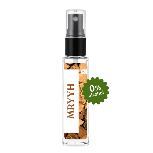 A clear glass perfume spray bottle with a black pump, featuring a white label with the brand name 'MRYYYH' in brown text and a wood-chip pattern. A green circular badge on the right reads '0% alcohol'.