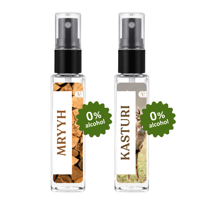 Two clear spray bottles with black pump tops on a white background. The left bottle has a white label with brown vertical text reading 'MRYYH' and a wood-chip photo, plus a green badge that says '0% alcohol'.