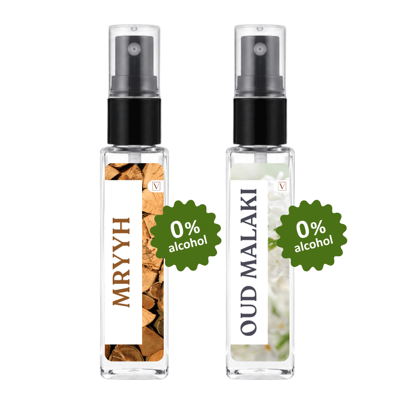 Two clear glass perfume spray bottles with black pumps on a white background. The left bottle is labeled 'MRYYH' with a brown wood-textured label and a green '0% alcohol' badge.