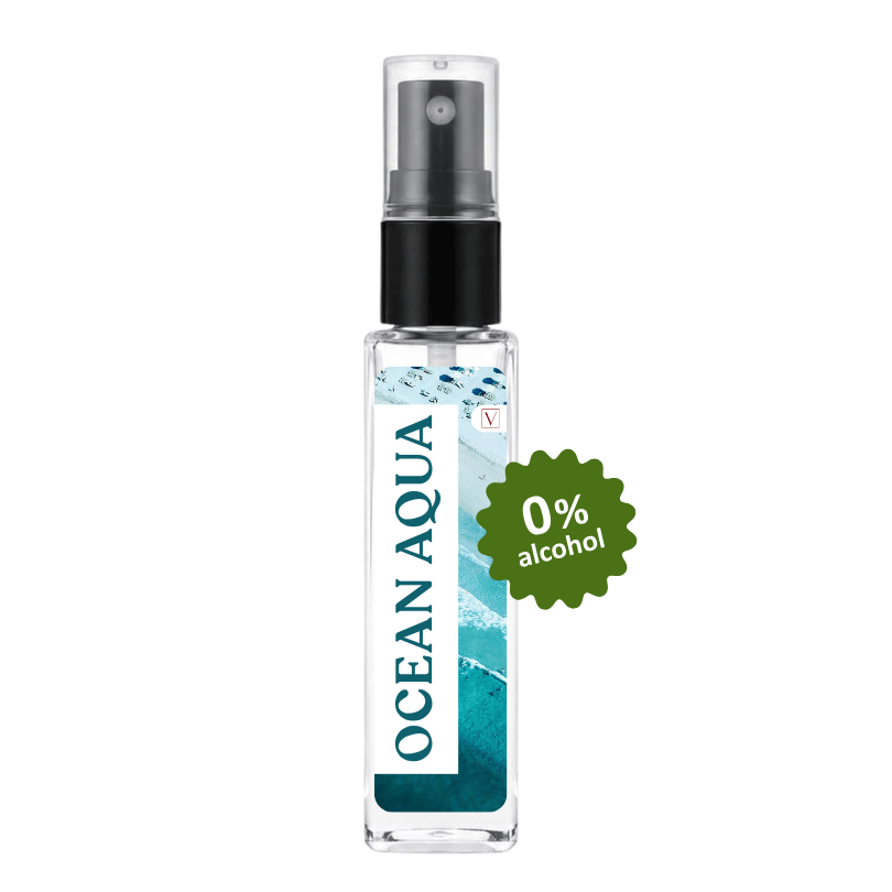 A clear glass spray bottle labeled OCEAN AQUA with a black pump and a green burst sticker reading 0% alcohol, shown on a plain white background.