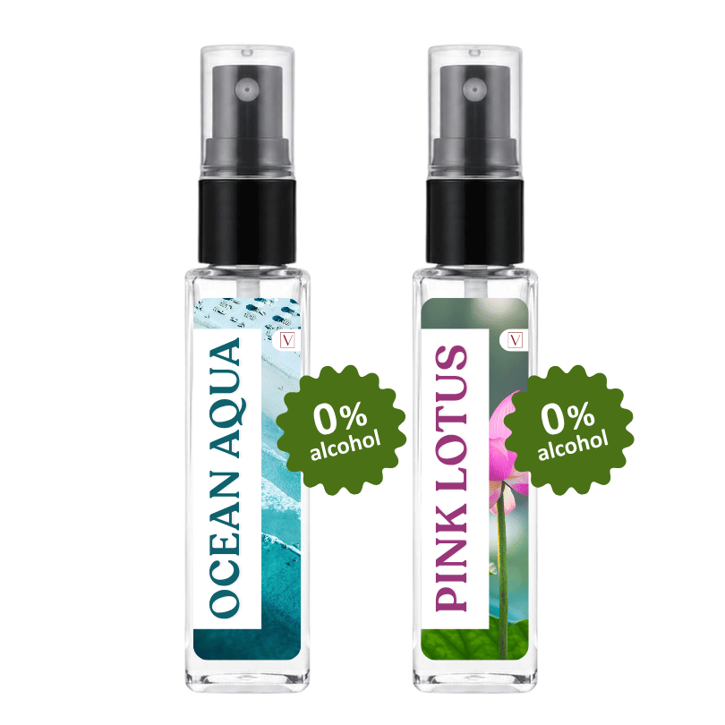 Two clear glass perfume spray bottles with black pump tops on a white background. The left bottle has a blue and white wave label reading 'OCEAN AQUA' and a green badge that says '0% alcohol'.