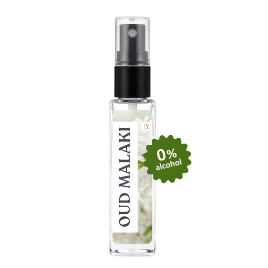 A clear glass perfume spray bottle with a black pump and a white label reading 'OUD MALAKI'. A green burst sticker on the right says '0% alcohol'.