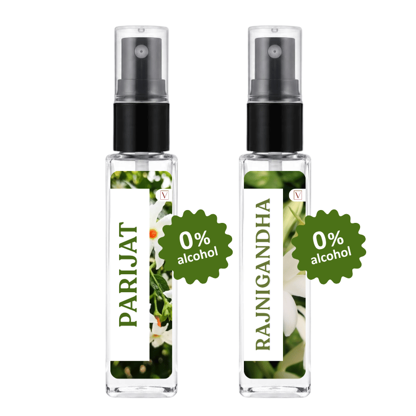 Two clear glass perfume spray bottles with black atomizers and white labels, shown side by side on a white background. The left bottle is labeled PARIJAT with a green 0% alcohol badge, and the right bottle is labeled RAJNIGANDHA with a green 0% alcohol badge.