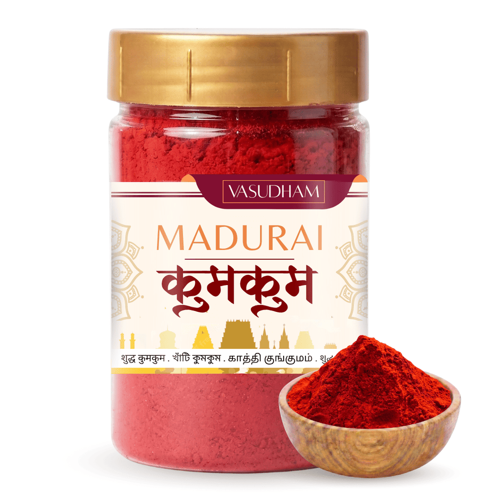 A jar of Vasudham Madurai Kumkum (red Indian henna) with a gold lid and a white label, shown alongside a small wooden bowl filled with the red powder on a white background.