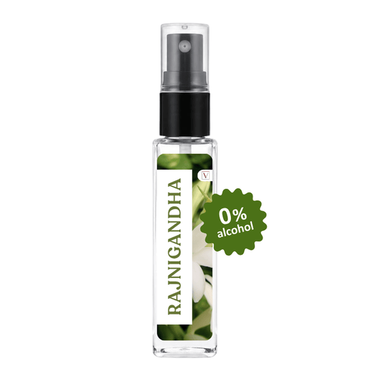 A clear glass spray bottle labeled RAJNIGANDHA with a black pump and a green burst sticker reading 0% alcohol, shown on a plain white background.