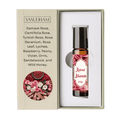 Vasudham Rose Bloom essential oil roller bottle in its open presentation box, featuring a beige exterior with a rose and spice illustration and a white interior.