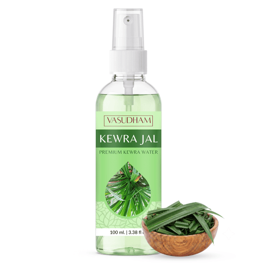 A 100 ml spray bottle of Vasudhami Kewra Jal premium kewra water, shown next to a small wooden bowl filled with fresh green kewra leaves on a white background.