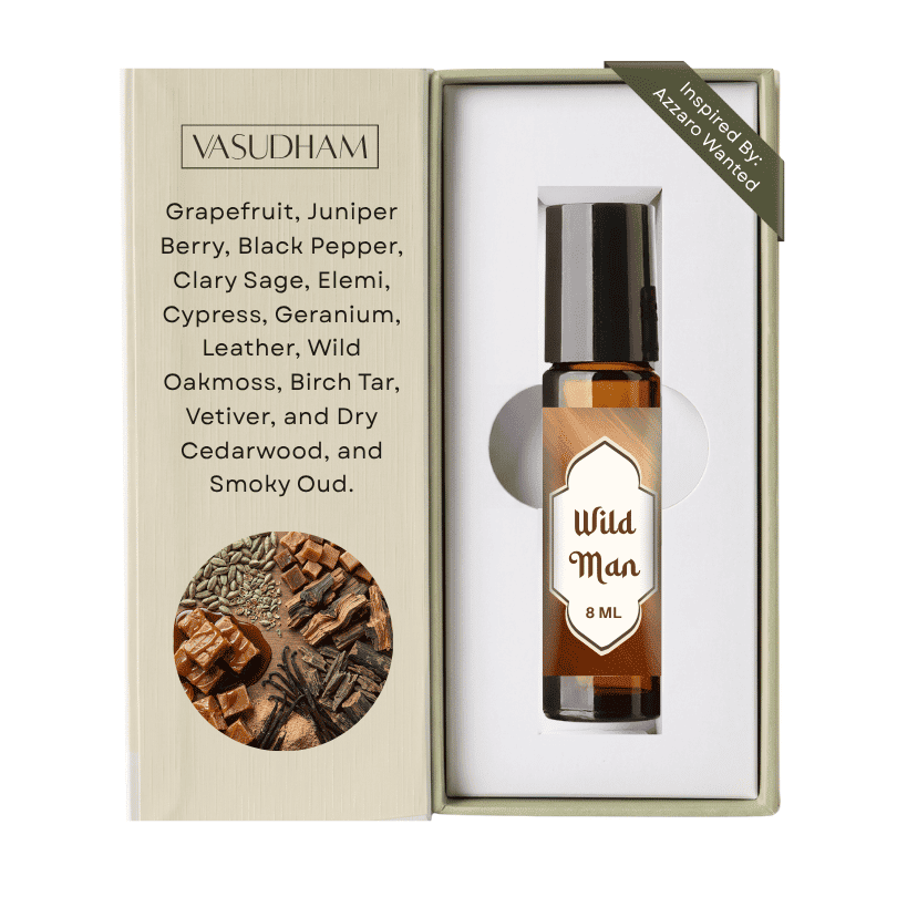 A boxed fragrance oil bottle labeled Wild Man 8 ML by Vasudham, shown in an open presentation box with printed ingredient text and a circular ingredient photo on a white background.