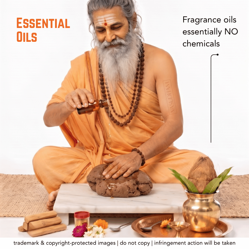 A bearded man in an orange robe sits cross-legged on a mat, pouring oil from a small bottle onto a brown herbal paste placed on a white board. Text on the image reads 'Essential Oils' and 'Fragrance oils essentially NO chemicals.